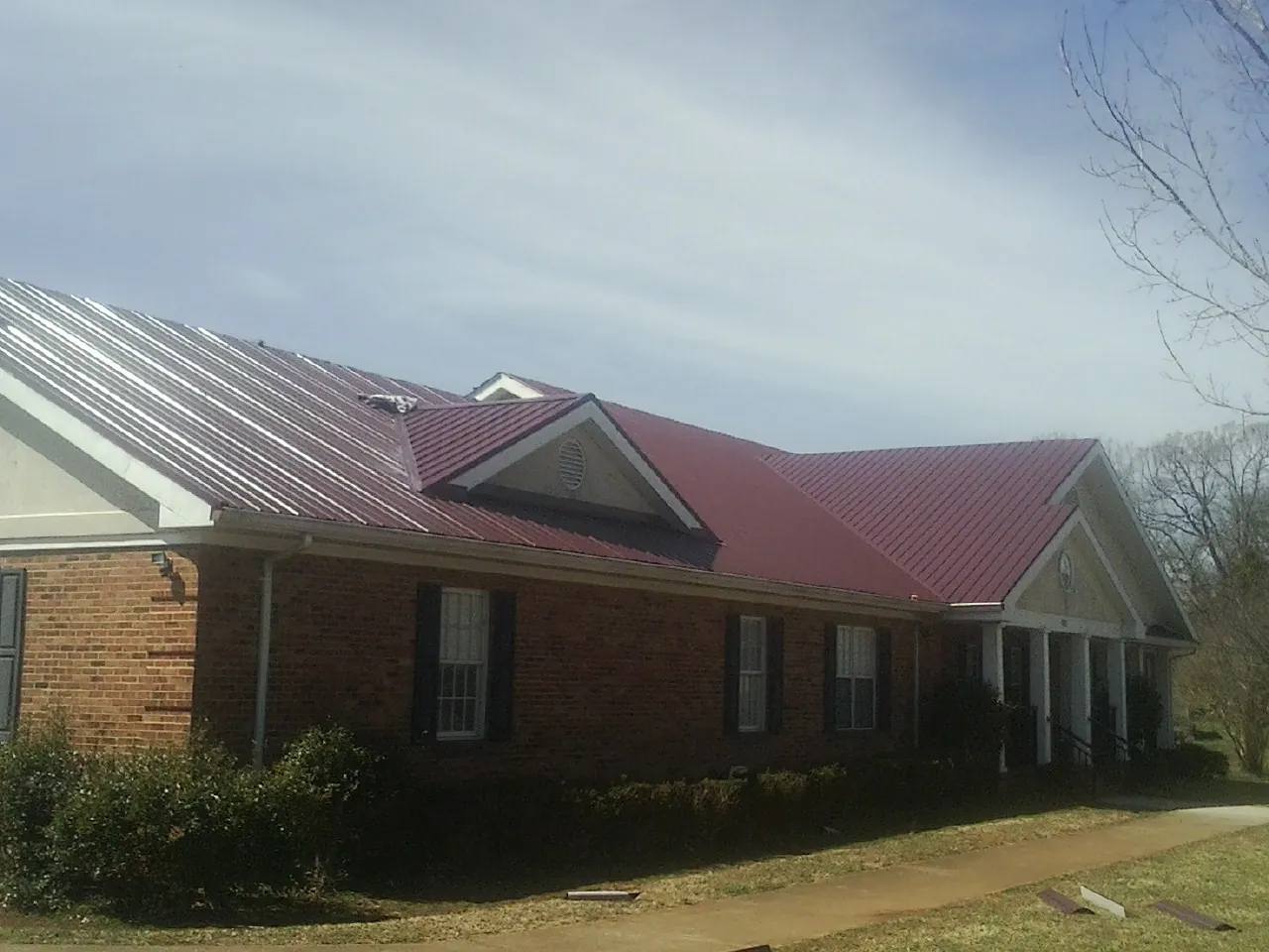 Red metal roof with gabled entries on a long brick building in Thurman