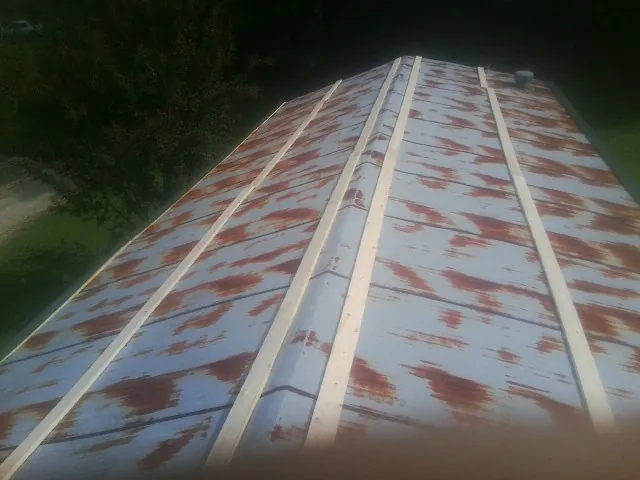 Rusted metal roof panels with new wood purlins before replacement — Storm Damage Roof Repair in Thurman by Roofing Brothers
