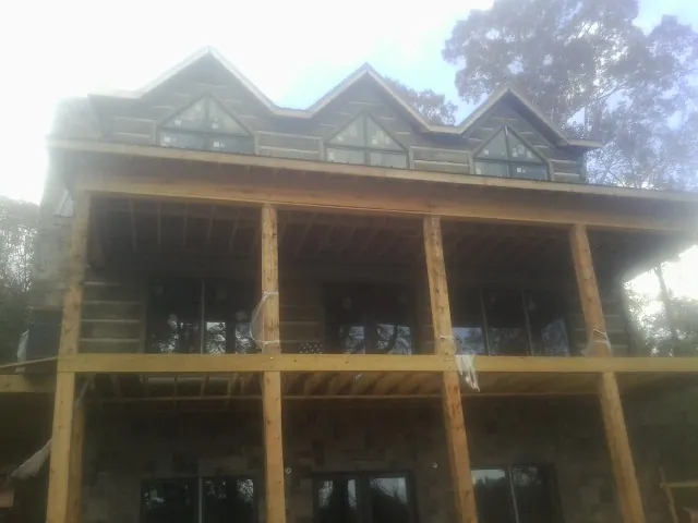 Dormers and porch framing on a large log home under construction — Roof Coating work by our crew in Thurman