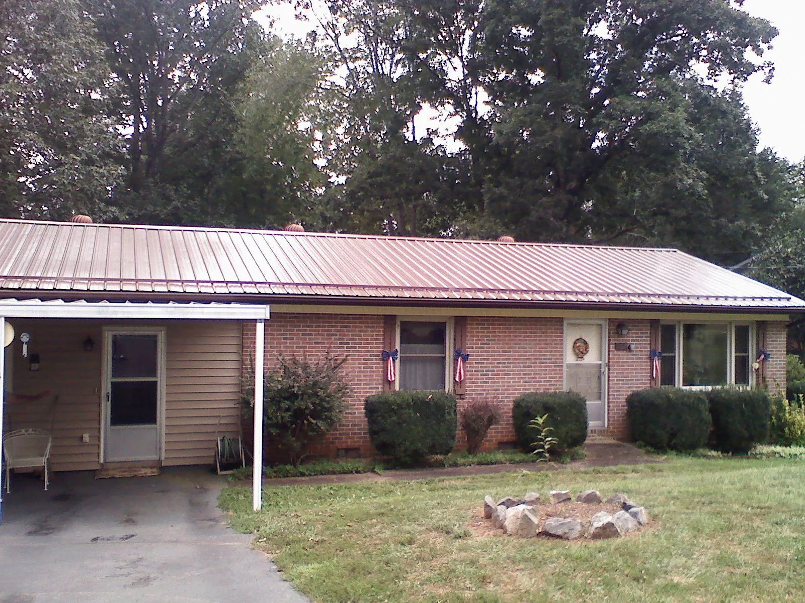 Bronze metal roof and carport on a brick ranch home — Roof Repair work by our crew in Thurman